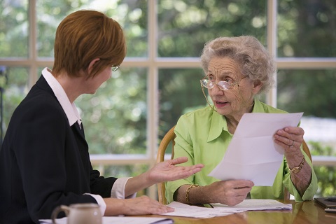 Elderly woman consulting a Wisconsin real estate lawyer to transfer property